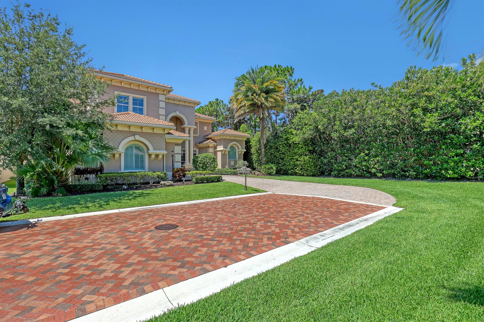 A two-story stucco house with a brick driveway and lush landscaping under a clear sky — 6464 Bellamalfi Street, Boca Raton FL 33496, BOCA RATON, FL