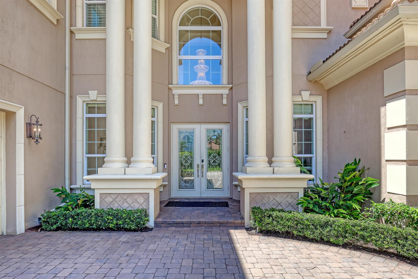 The exterior of a house features a grand entrance with two large columns and double doors — 6464 Bellamalfi Street, Boca Raton FL 33496, BOCA RATON, FL