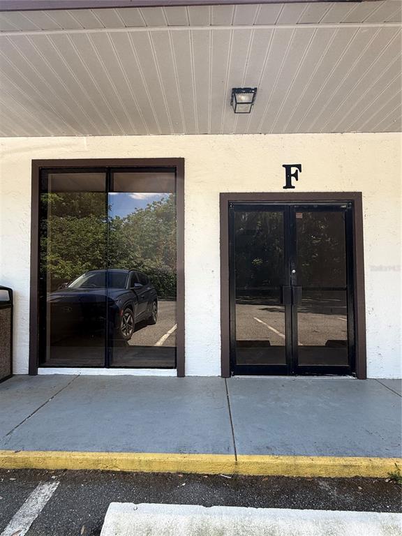The exterior view shows a building entrance labeled F with glass doors and windows — 3380 SE LAKE WEIR AVENUE UNIT F, OCALA, FL