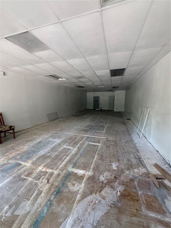 An empty commercial space features a drop ceiling, white walls, and a bare concrete floor — 3380 SE LAKE WEIR AVENUE UNIT F, OCALA, FL