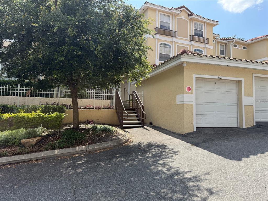 A three-story townhouse exterior with a garage, a staircase, and a large tree — 692 SEABROOK COURT UNIT 102, ALTAMONTE SPRINGS, FL
