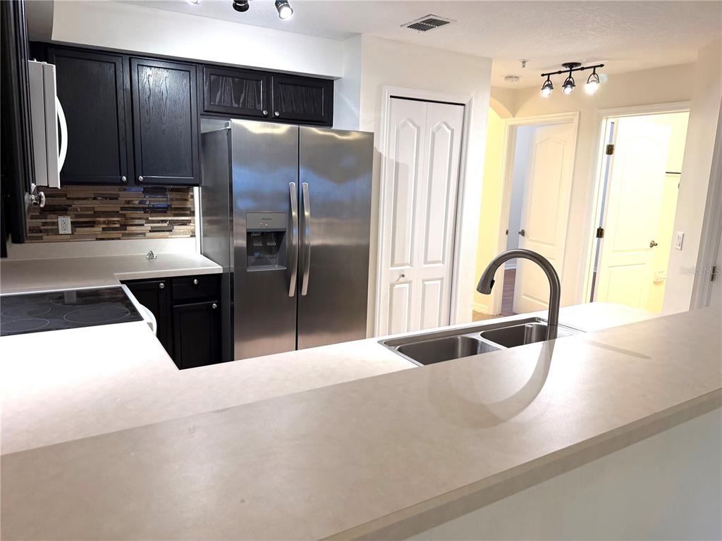 A kitchen features dark cabinets, stainless steel appliances, a breakfast bar, and a double sink — 692 SEABROOK COURT UNIT 102, ALTAMONTE SPRINGS, FL