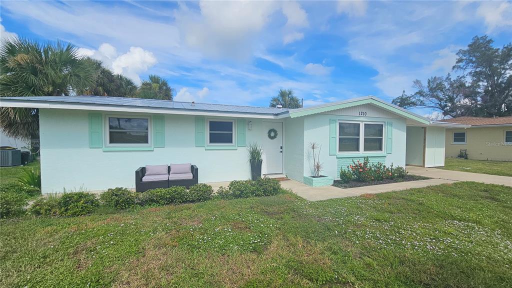 A light green, single-story house with a metal roof and a small front yard — 1210 S MARYKNOLL ROAD, ENGLEWOOD, FL