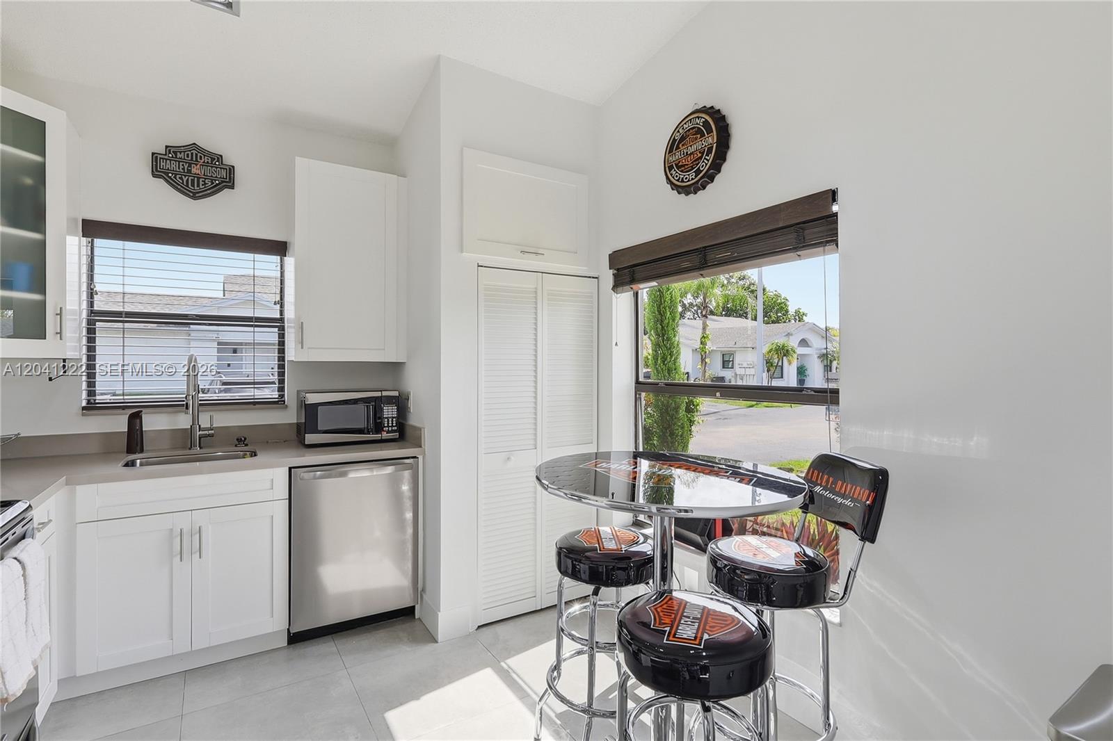 A kitchen features white cabinets, stainless steel appliances, and a Harley-Davidson themed dining set — 6443 SW 152nd Cir Pl # 43, Miami FL 33193, MIAMI, FL