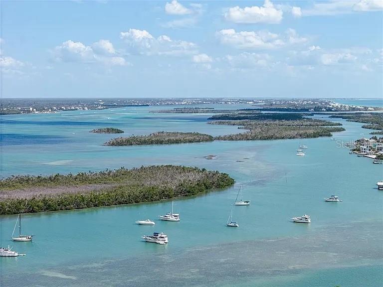 An aerial view of a coastal waterway featuring several boats anchored near mangrove islands — 15184 MALCOLM AVENUE, PORT CHARLOTTE, FL