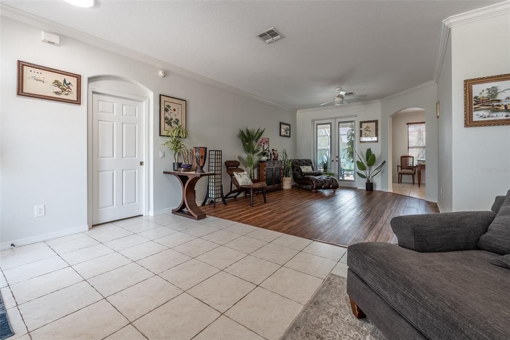 A living room features a tiled entryway transitioning into wood-look flooring and glass patio doors — 15681 SW 16TH TERRACE, OCALA, FL