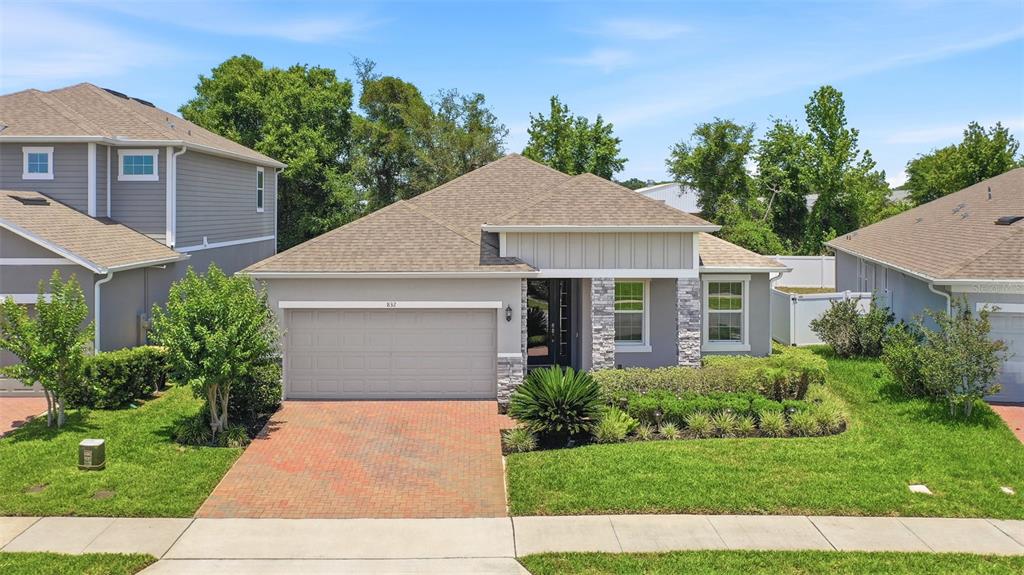 A single-story house with a brick driveway, gray stucco exterior, and a two-car garage — 832 JETWAY STREET, ORANGE CITY, FL