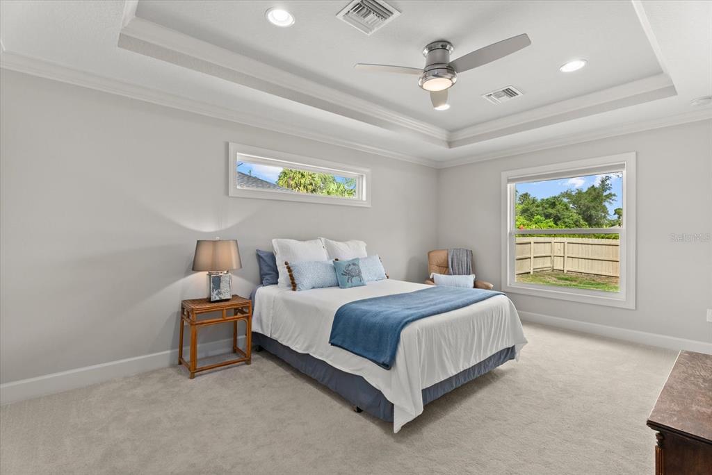 A bedroom features a tray ceiling, a ceiling fan, carpeted floors, and two windows — 1538 KEYHOLE STREET, NORTH PORT, FL