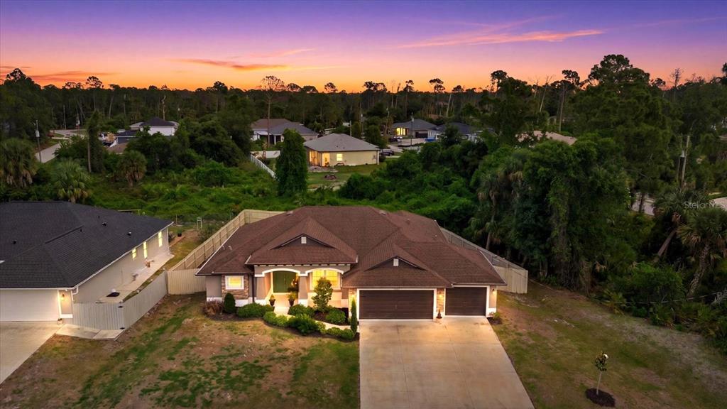 An aerial view shows a single-story house with a brown roof and a concrete driveway — 1538 KEYHOLE STREET, NORTH PORT, FL