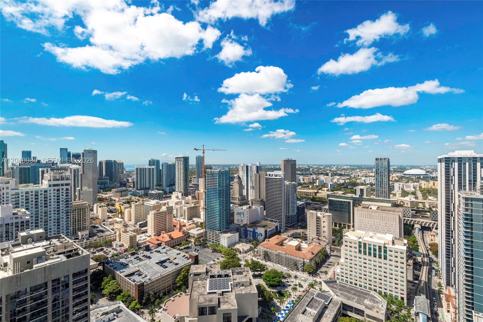 A high-angle view of a dense urban cityscape featuring numerous skyscrapers under a blue sky — 398 NE 5th St # 4001, Miami FL 33132, MIAMI, FL