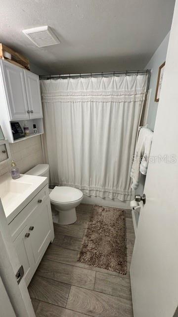 A kitchen features white cabinets, a wood countertop, a stainless steel dishwasher, and gray flooring — 2808 W AZEELE UNIT 103, TAMPA, FL