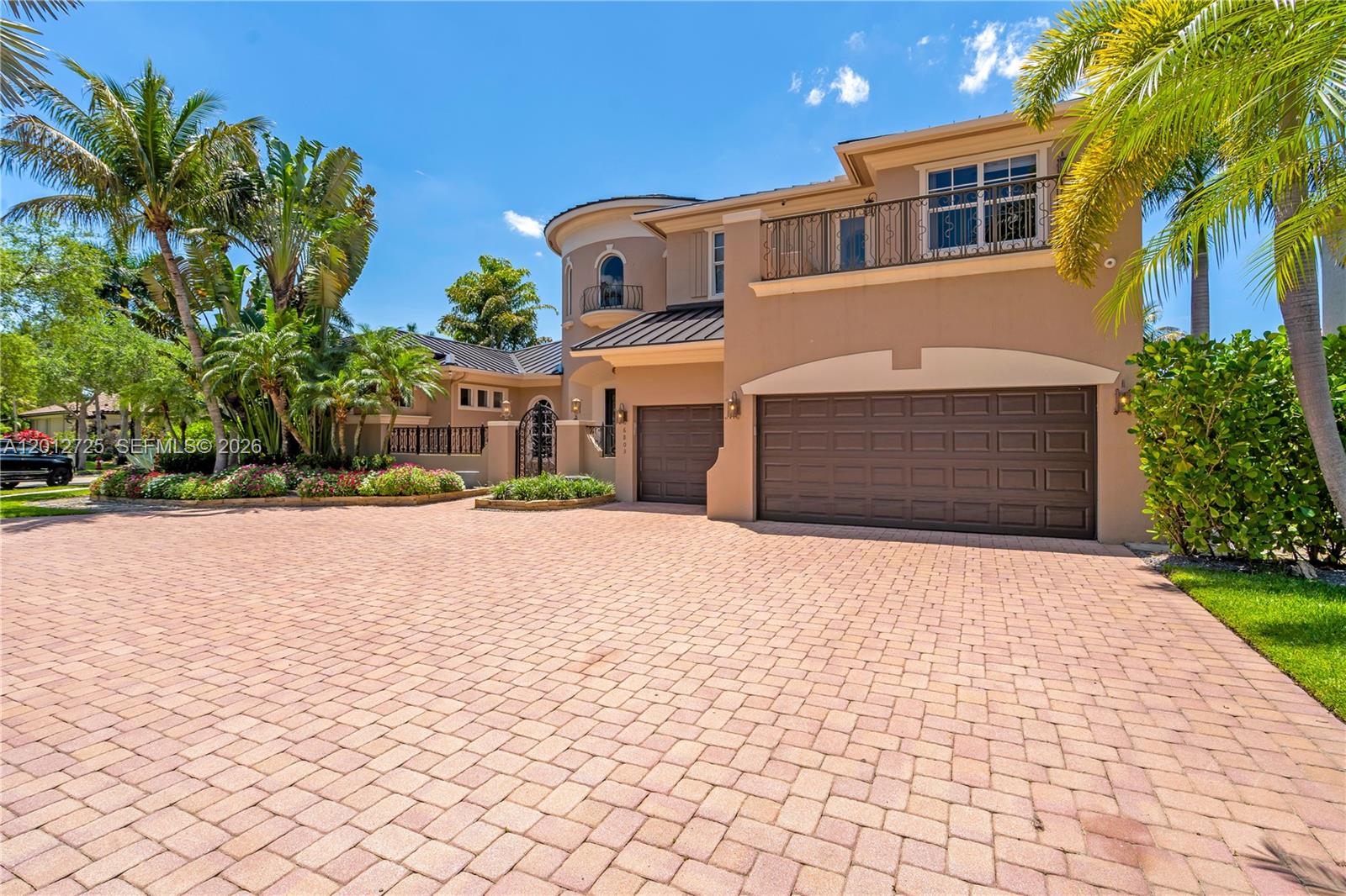 A two-story tan stucco house features a large paver driveway and a three-car garage — 6803 NW 116th Ave, Parkland FL 33076, PARKLAND, FL