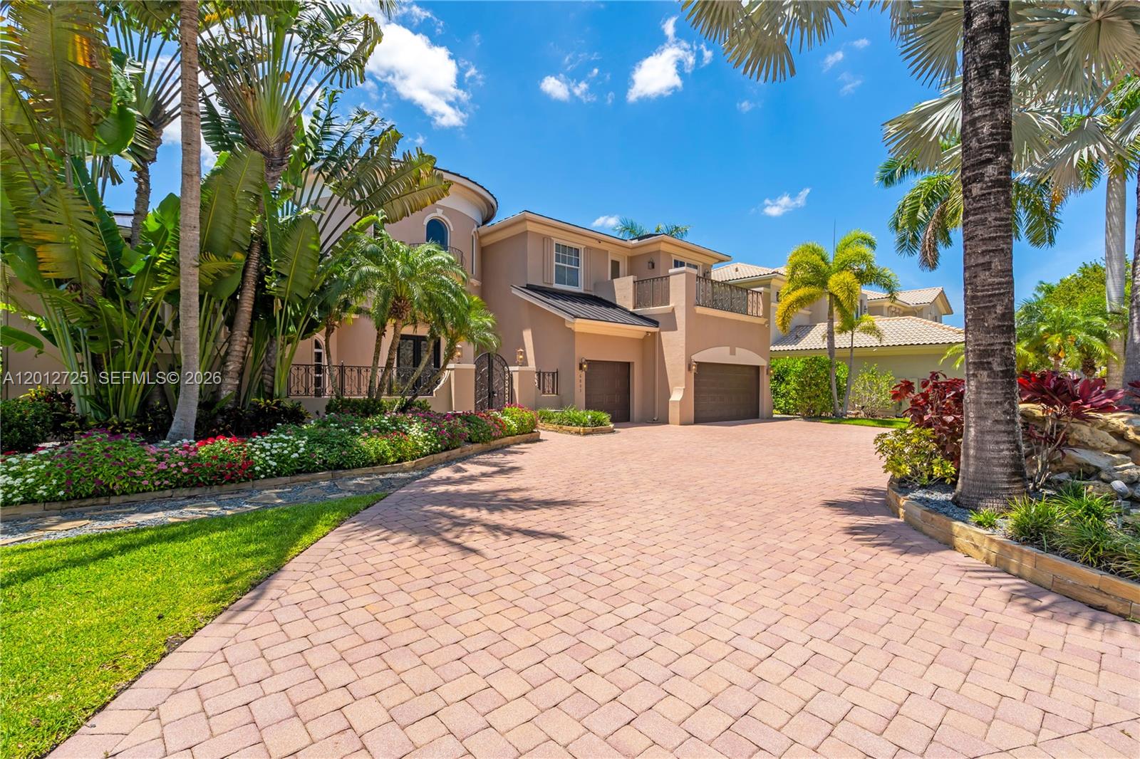 A two-story stucco house features a paved driveway, a two-car garage, and lush landscaping — 6803 NW 116th Ave, Parkland FL 33076, PARKLAND, FL