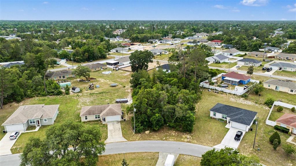 An aerial view shows a residential neighborhood with houses, driveways, and wooded lots — 00000 SW 23RD AVENUE ROAD, OCALA, FL