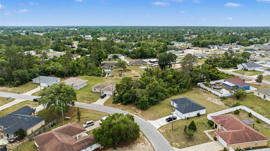 An aerial view shows a suburban neighborhood with single-family homes, paved roads, and wooded areas — 00000 SW 23RD AVENUE ROAD, OCALA, FL