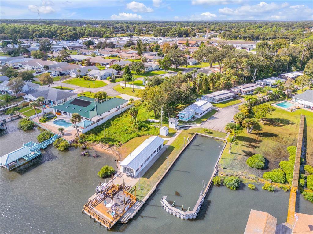 An aerial view shows a waterfront property with a boat slip, dock, and house — 2201 S RIDGEWOOD AVENUE UNIT 28, EDGEWATER, FL