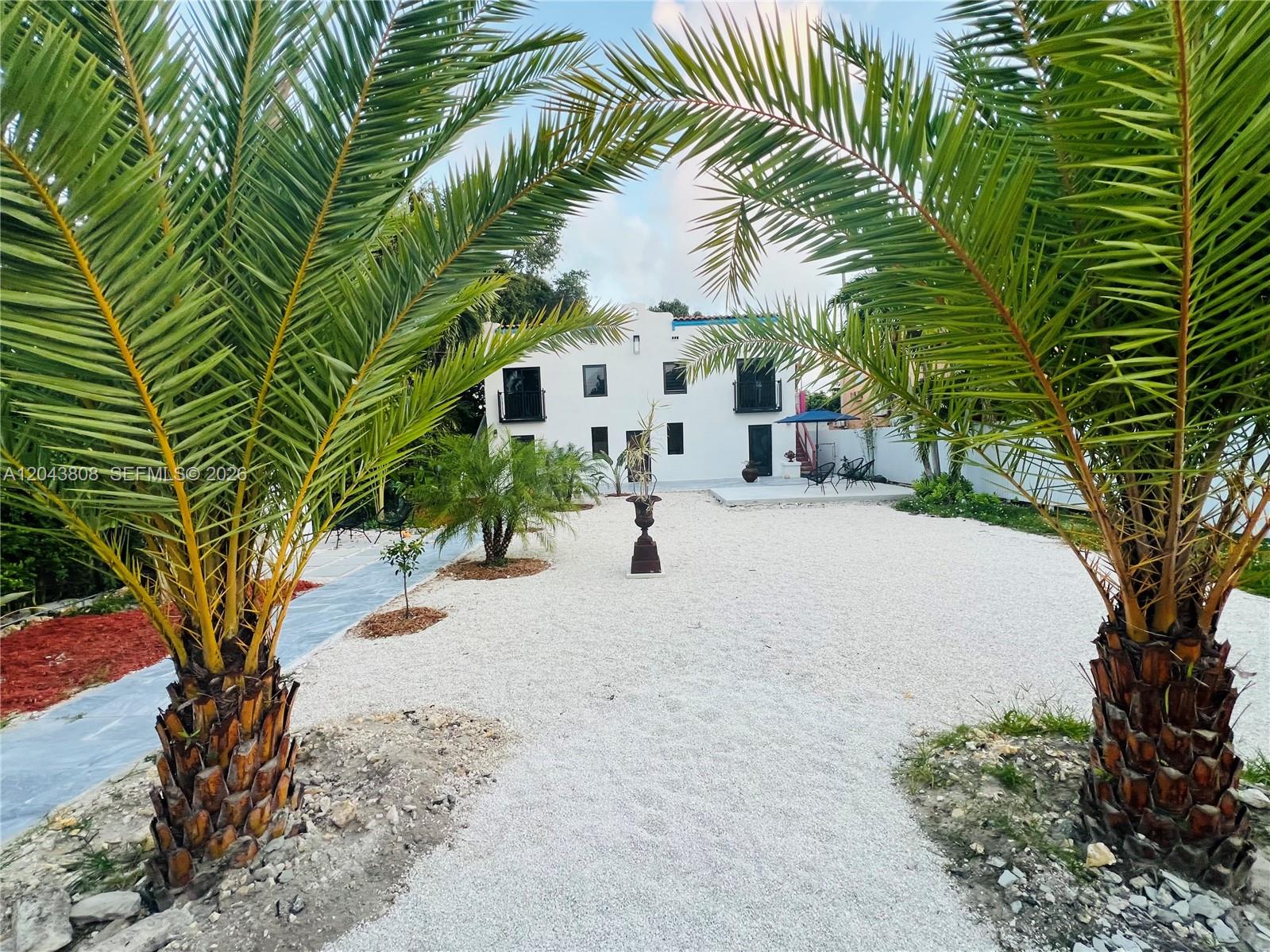 A white two-story house sits behind a gravel yard framed by two large palm trees — 2134 SW 11th St, Miami FL 33135, MIAMI, FL