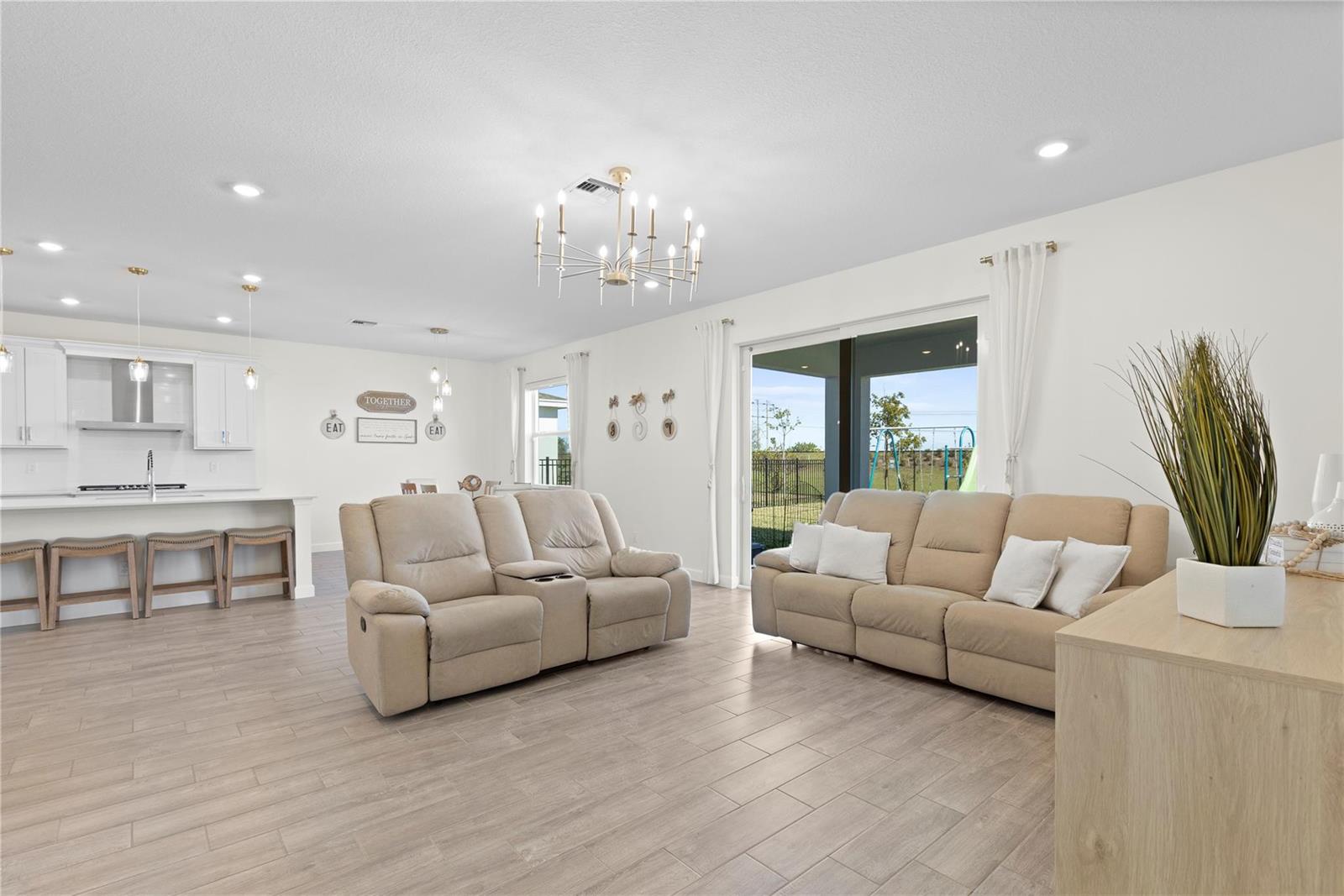 The rear exterior of a two-story house with a covered patio and a grassy backyard — 1148 Tangled Orchard Trace, Loxahatchee FL 33470, LOXAHATCHEE, FL