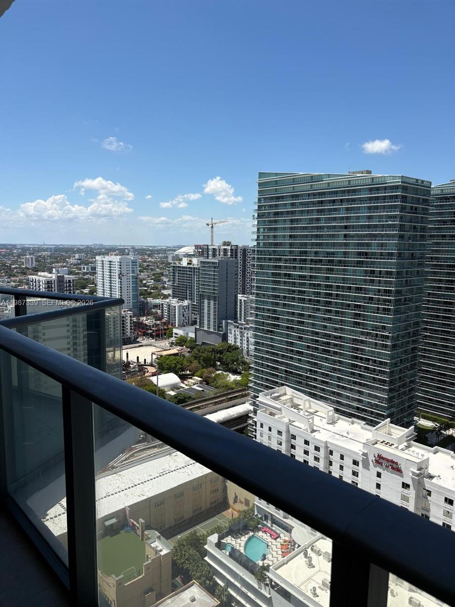 A high-angle view from a balcony overlooking a city skyline with several tall buildings — 1300 S Miami Ave # 2911, Miami FL 33130, MIAMI, FL
