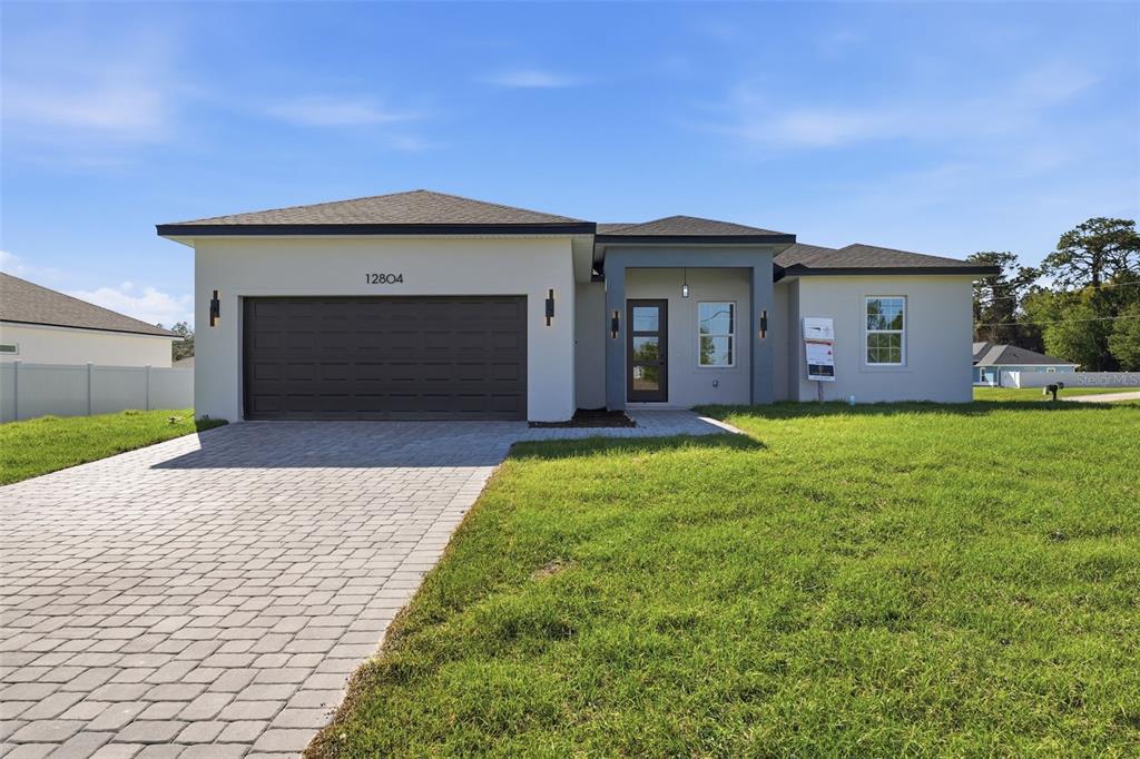 A single-story house features a paved driveway, a two-car garage, and a covered entryway — 12804 SW 74TH TERRACE, OCALA, FL