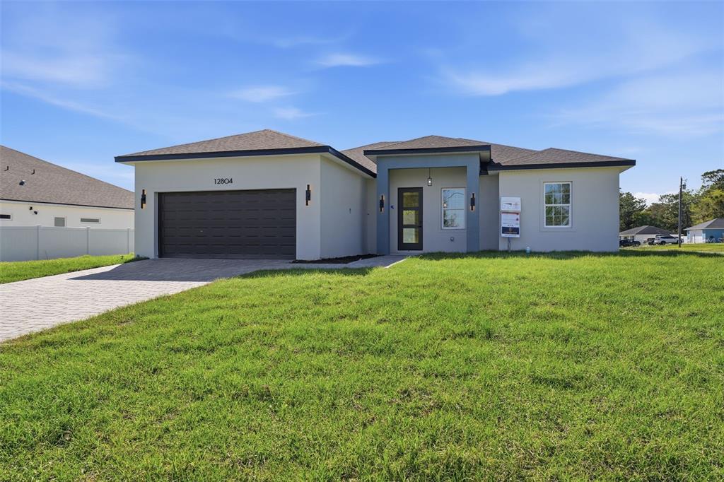 A single-story house with a gray exterior, a two-car garage, and a paved driveway — 12804 SW 74TH TERRACE, OCALA, FL