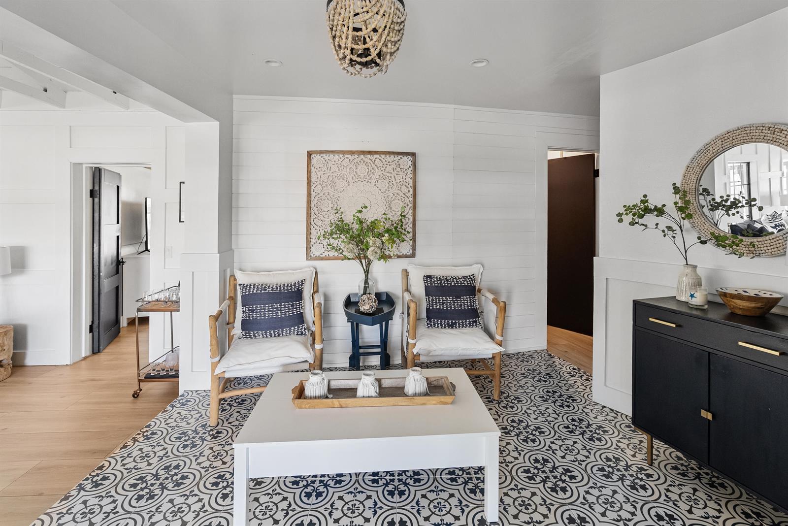 A sitting area features patterned tile flooring, two white chairs, and a central coffee table — 711 SW 27th Way, Boynton Beach FL 33435, BOYNTON BEACH, FL