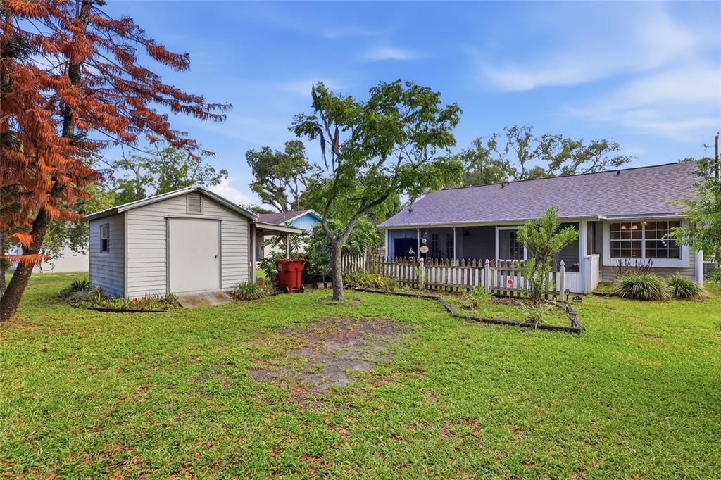 A backyard features a small shed, a house with a screened porch, and a large tree — 1405 E FRANCES AVENUE, PLANT CITY, FL
