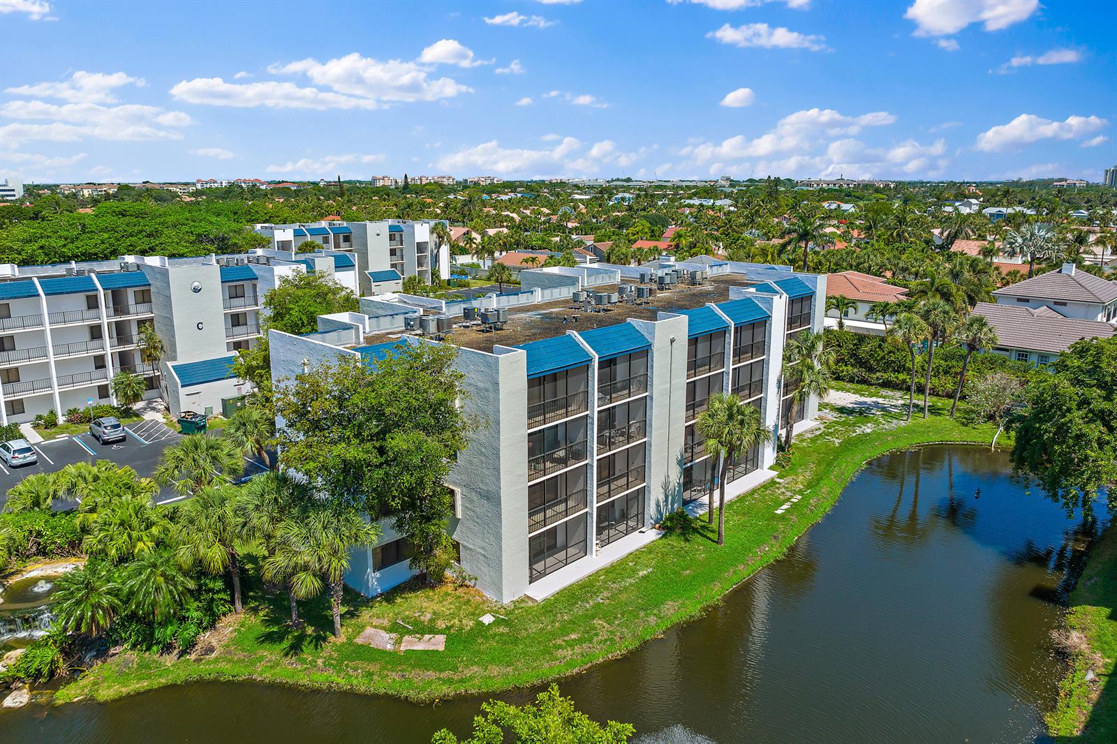 An aerial view of a multi-story apartment building with blue roofs next to a pond — 1605 S Us Highway 1 # D301, Jupiter FL 33477, JUPITER, FL
