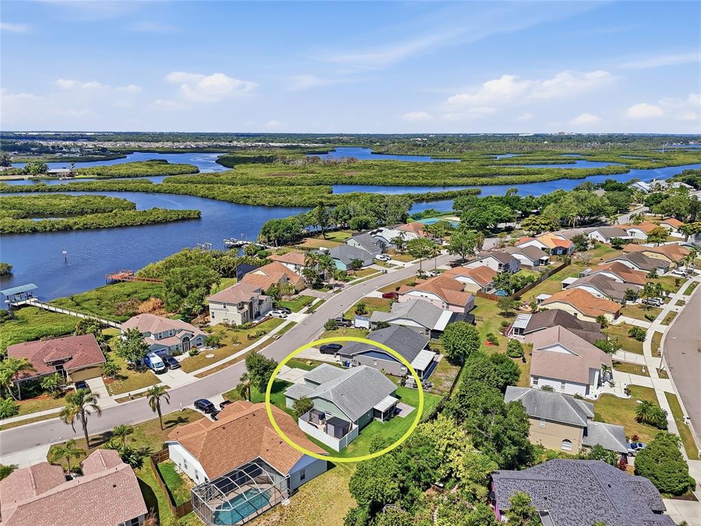 An aerial view shows a light green house with a fenced yard in a neighborhood — 4839 14TH AVENUE E, BRADENTON, FL