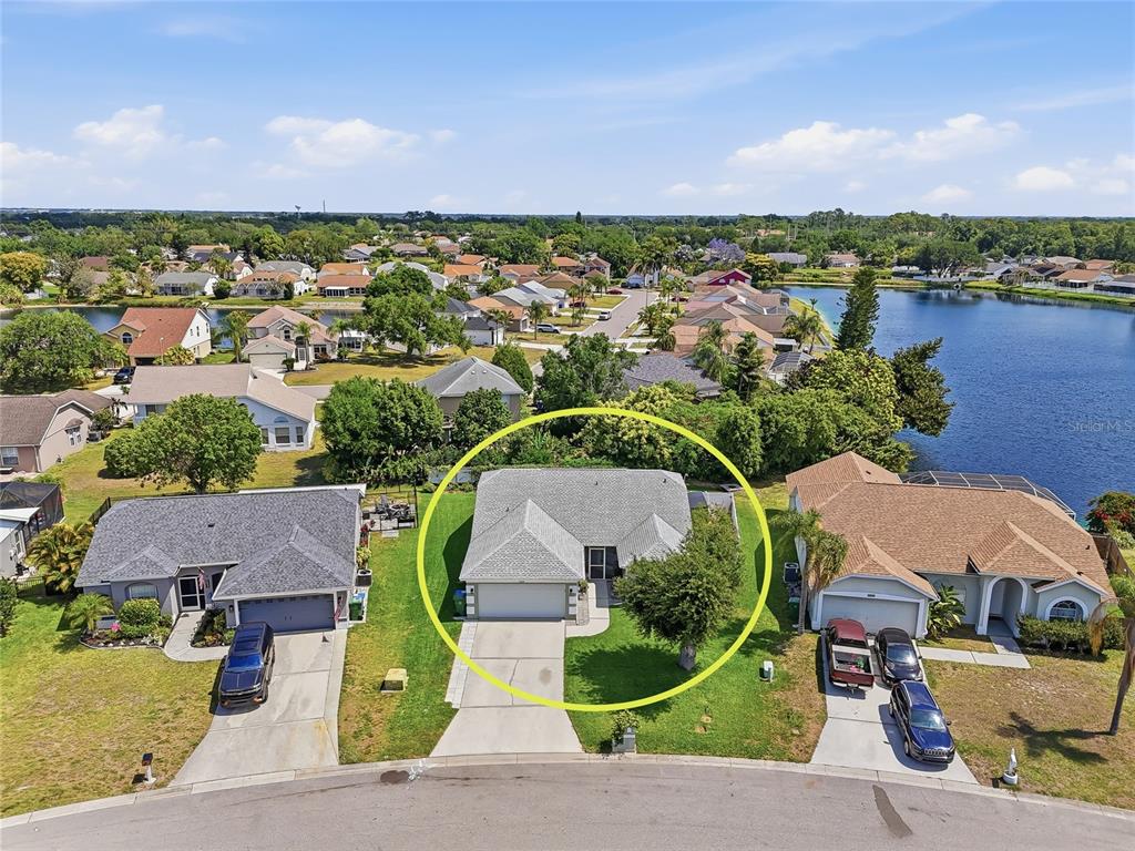 An aerial view shows a single-story house with a gray roof and driveway — 4839 14TH AVENUE E, BRADENTON, FL