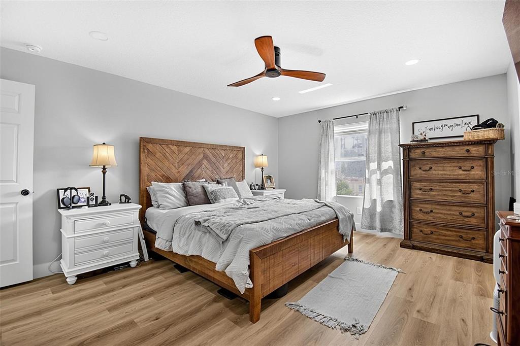 A bedroom features a wooden bed frame, a white nightstand, and a tall wooden dresser — 1 ROUND TREE DRIVE, PALM COAST, FL