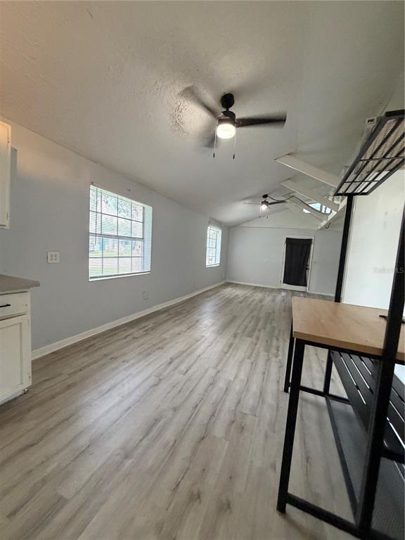 A long room features light wood-look flooring, two ceiling fans, and white walls — 1505 N ORANGE STREET, PLANT CITY, FL
