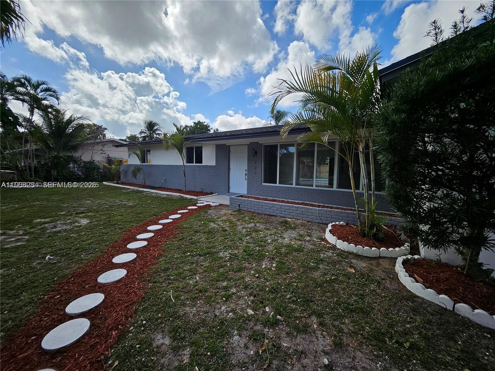A single-story house with a gray brick exterior, white trim, and a stone walkway — 221 SW 53rd Ave, Plantation FL 33317, PLANTATION, FL