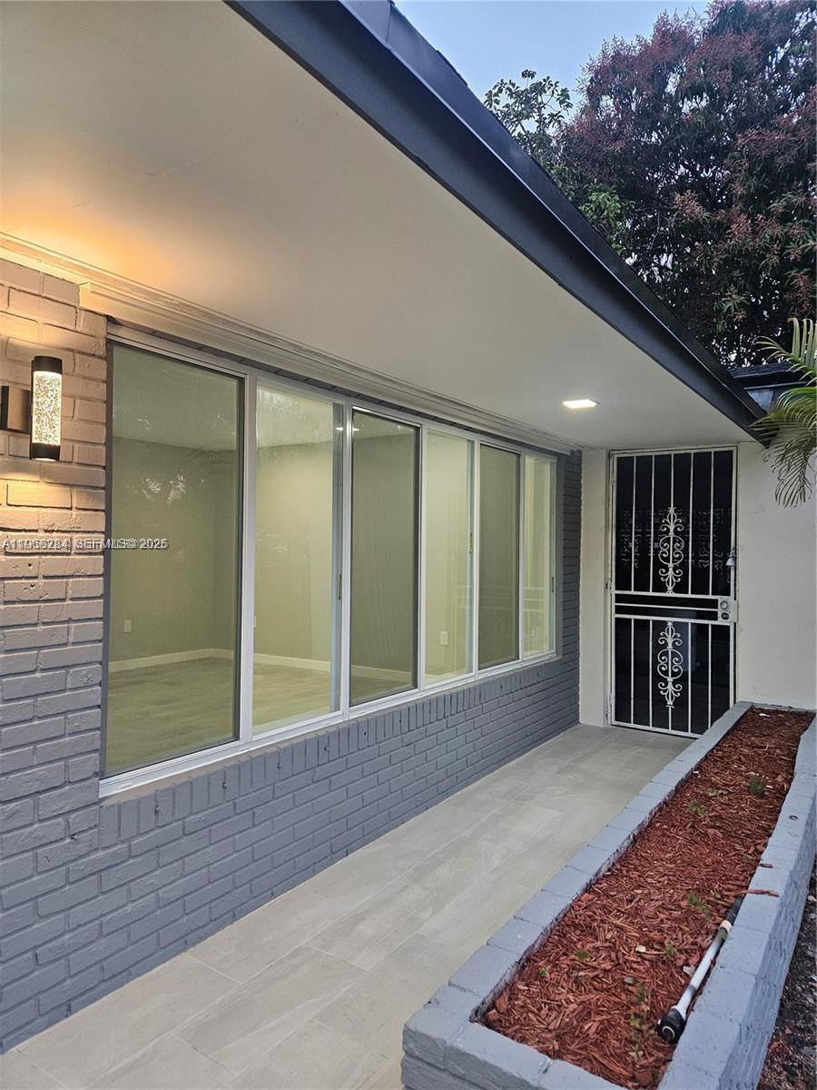 A gray brick exterior wall features a large window and a decorative metal security door — 221 SW 53rd Ave, Plantation FL 33317, PLANTATION, FL