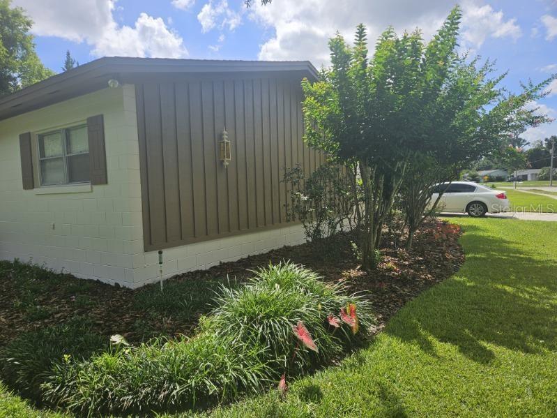 The exterior of a house features a white concrete block base and brown vertical siding — 120 LARKWOOD DRIVE, SANFORD, FL