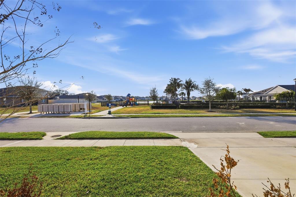 A neighborhood street view featuring a playground, mailboxes, and residential homes under a blue sky — 2029 APALACHICOLA LANE, SANFORD, FL