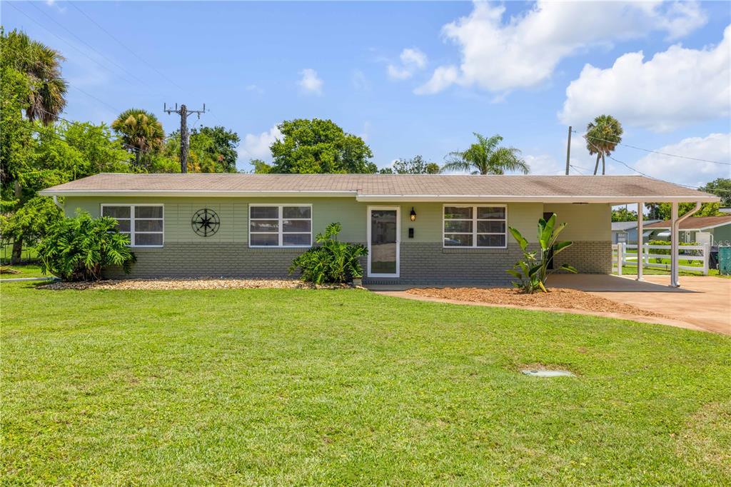 A single-story house with a green and gray exterior, a front lawn, and a carport — 1807 S SEGRAVE STREET, SOUTH DAYTONA, FL