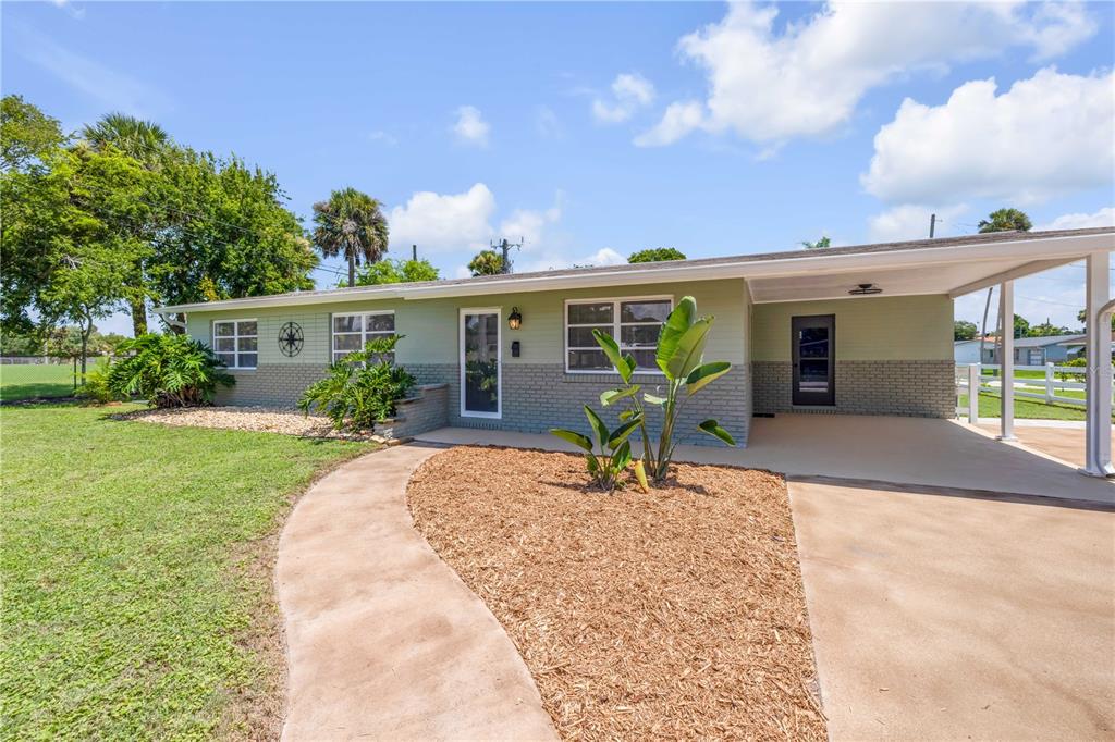 A single-story house with a green and gray brick exterior and a covered carport — 1807 S SEGRAVE STREET, SOUTH DAYTONA, FL