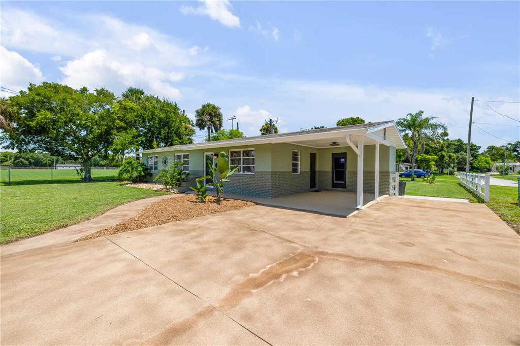 A single-story house with a green exterior, brick base, and a covered carport — 1807 S SEGRAVE STREET, SOUTH DAYTONA, FL