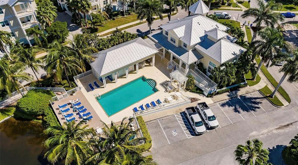 An aerial view shows a house with a swimming pool, patio, and adjacent parking lot — 7840 34TH AVENUE W UNIT 102, BRADENTON, FL