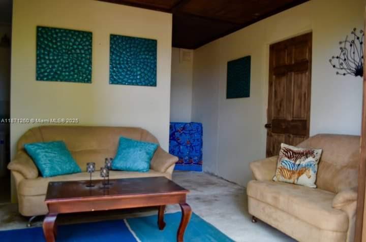 A living room features two tan sofas, a wooden coffee table, and blue wall art — 20 RM Cardiff Hall Villa St Ann, Jamaica, NA, NA