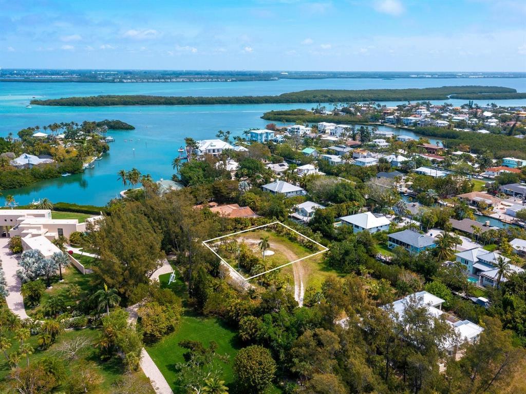 An aerial view shows a vacant, rectangular lot outlined in white amidst a coastal neighborhood — 6604 GULF OF MEXICO DRIVE, LONGBOAT KEY, FL