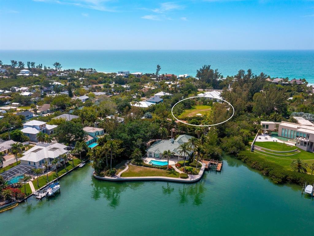 An aerial view shows a waterfront house with a pool and a large grassy lot — 6604 GULF OF MEXICO DRIVE, LONGBOAT KEY, FL