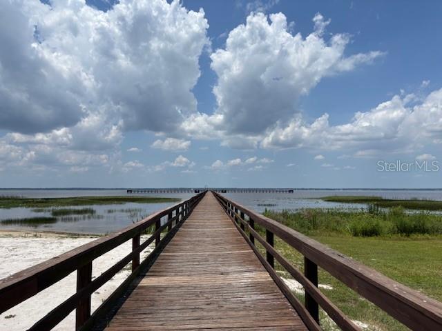 A long wooden boardwalk extends over a marshy area toward a large body of water — 3270 AZALEA DRIVE, INDIAN LAKE ESTATES, FL