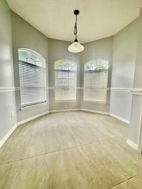 A breakfast nook features large arched windows, light-colored tile flooring, and a hanging pendant light — 4903 WATERSIDE POINTE CIRCLE, ORLANDO, FL