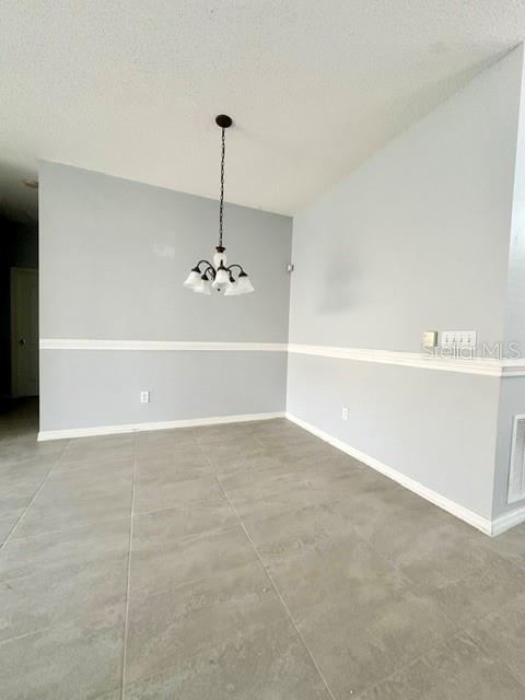 A dining area with light gray walls, white chair rail molding, tile flooring, and a chandelier — 4903 WATERSIDE POINTE CIRCLE, ORLANDO, FL