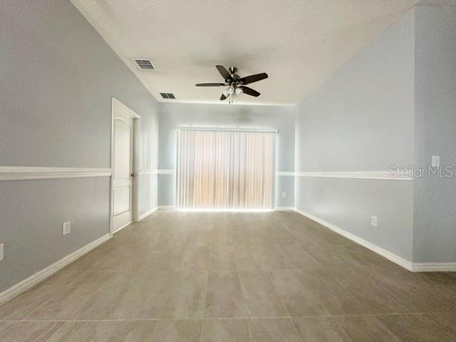 An empty room features light gray walls, white trim, tile flooring, and a ceiling fan — 4903 WATERSIDE POINTE CIRCLE, ORLANDO, FL