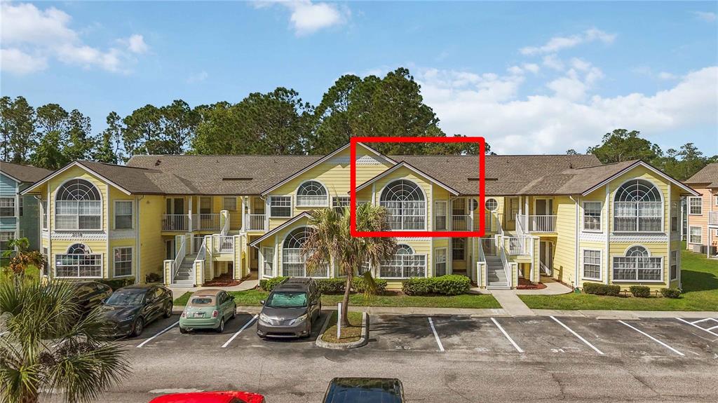 A three-story yellow apartment building features a prominent arched window on the top floor — 2040 ROYAL BAY BOULEVARD UNIT 30, KISSIMMEE, FL