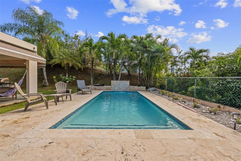 A rectangular swimming pool sits on a stone patio surrounded by palm trees and landscaping — 2A Calle del Sol CALLE DEL SOL, FAJARDO, PR