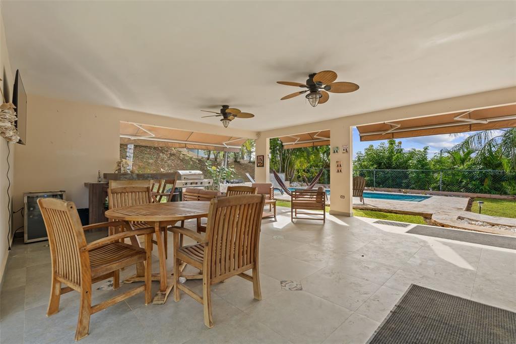 A covered patio features a dining set, outdoor kitchen, and views of a swimming pool — 2A Calle del Sol CALLE DEL SOL, FAJARDO, PR